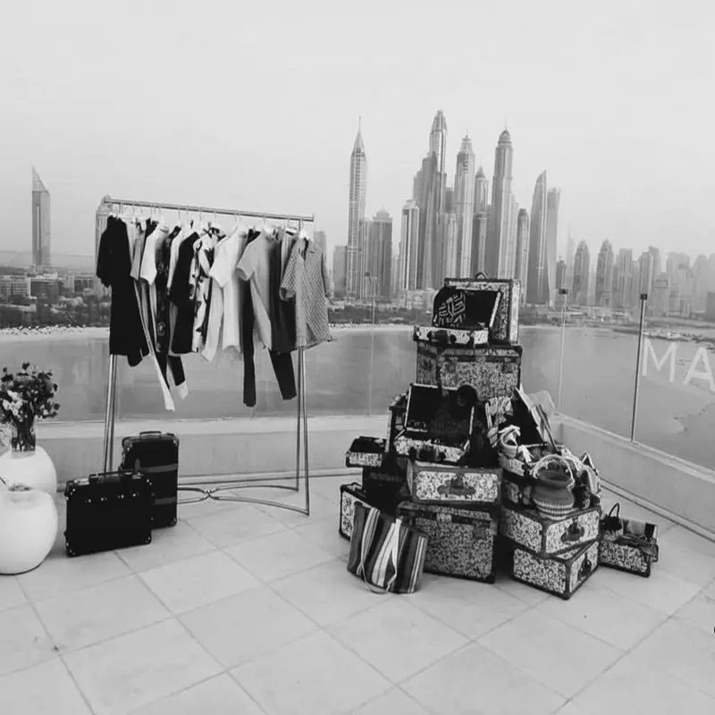 Destination wardrobe styling in Dubai — clothing rail and trunks overlooking the skyline
