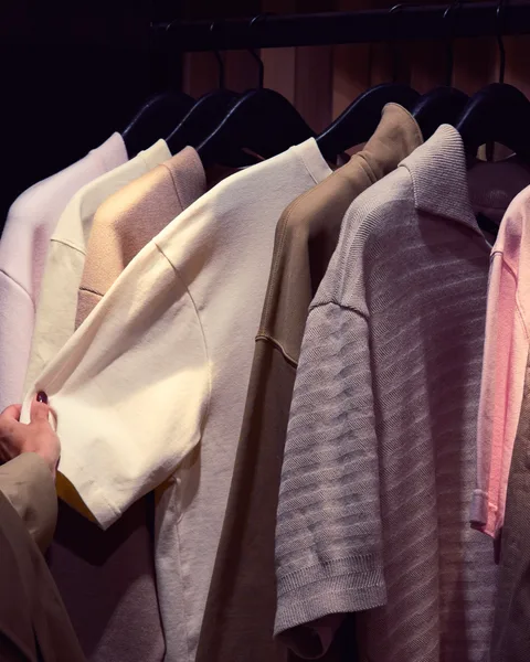 Men's full wardrobe reset — polo shirts and knitwear organised in soft neutral tones