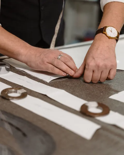 Tailor measuring cloth for a men's bespoke made-to-measure suit in London